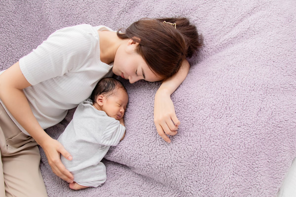 Single mom and newborn baby  is sleeping on bed. Newborn baby ag